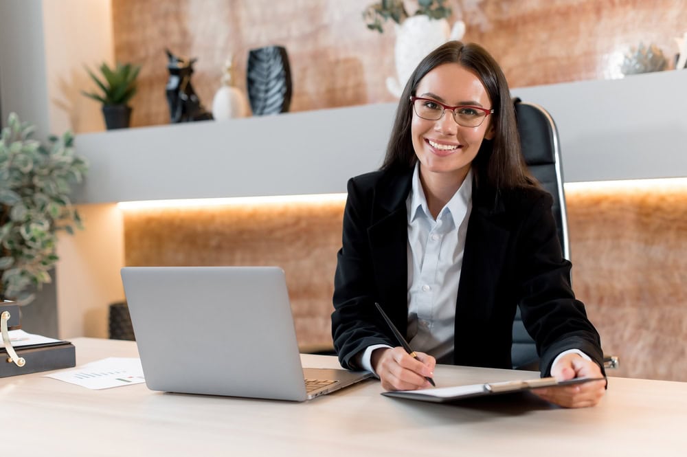 Portrait of a franchise support agent smiling at the camera waiting to help potential franchisees learn how to start their own car insurance franchise.