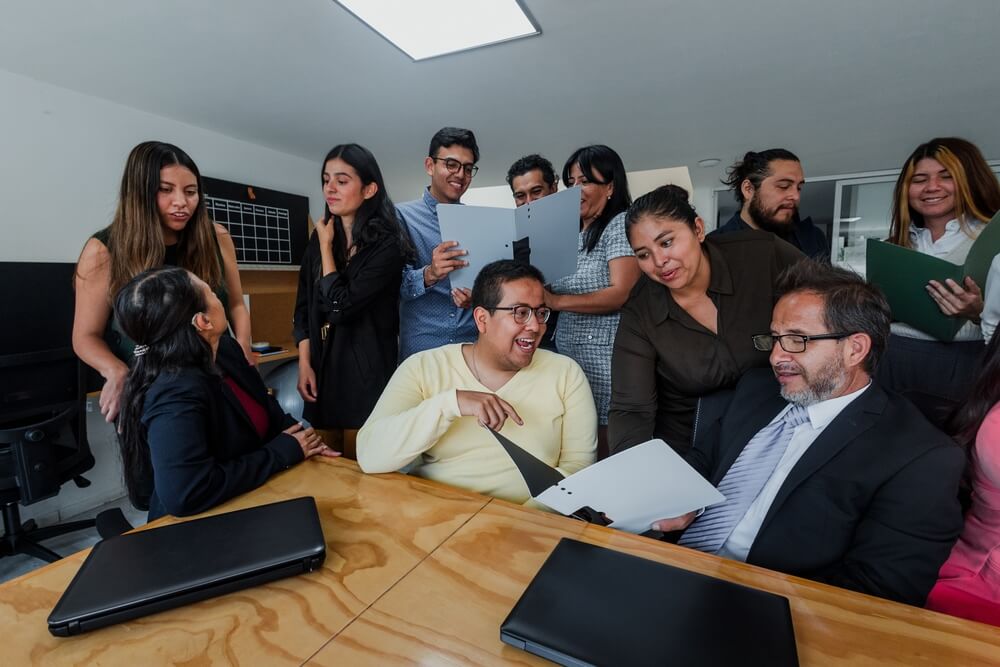 Team of professionals collaborating around a conference table, representing teamwork and leadership among Hispanic Entrepreneurs.
