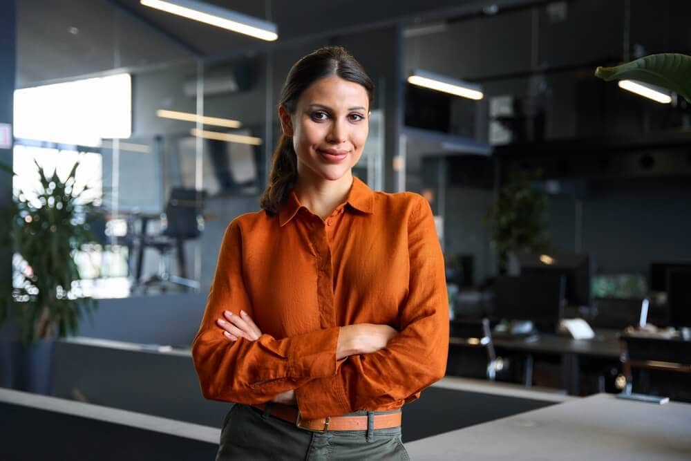 Professional Latina entrepreneur standing confidently in a modern office, representing top Latino and Hispanic business opportunities for entrepreneurs.