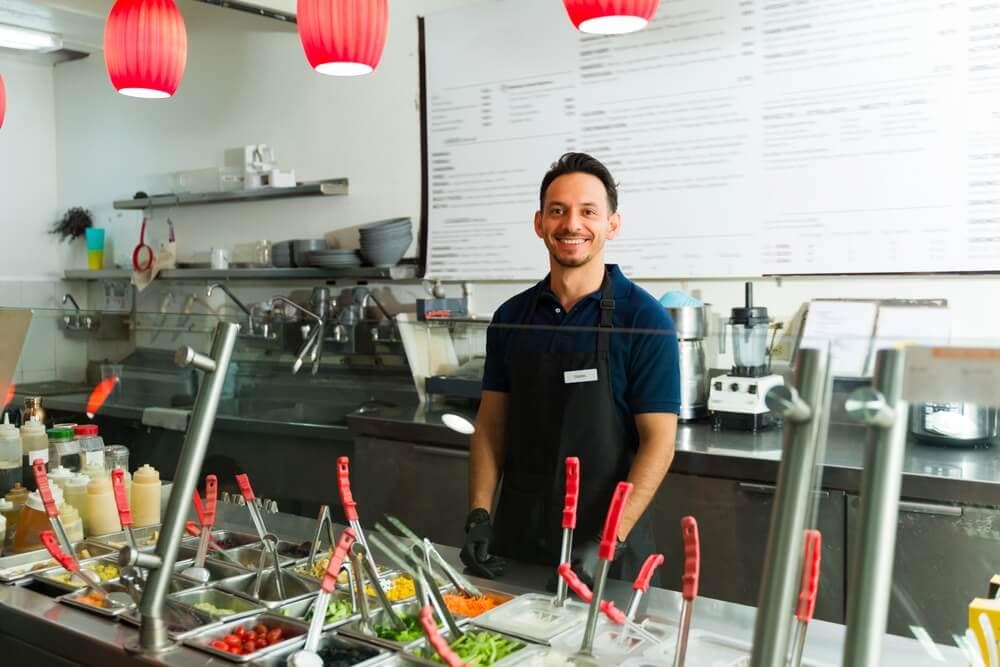 Small business owner working behind a restaurant counter, showcasing one of the top Latino and Hispanic business opportunities for entrepreneurs.