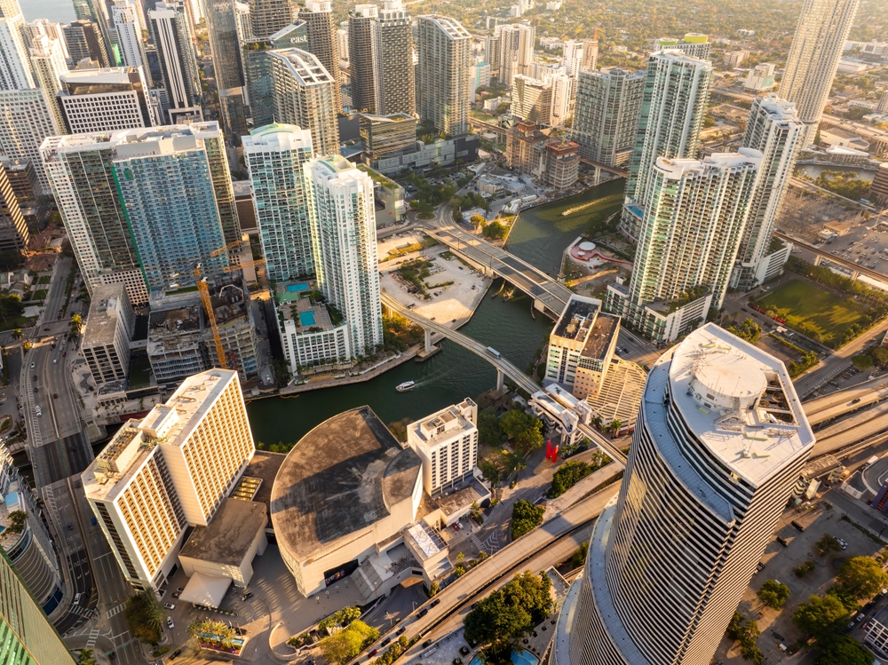 Aerial view of downtown Miami with high-rise buildings, bridges, and waterfront streets, showing the business potential to open an insurance franchise in Miami.