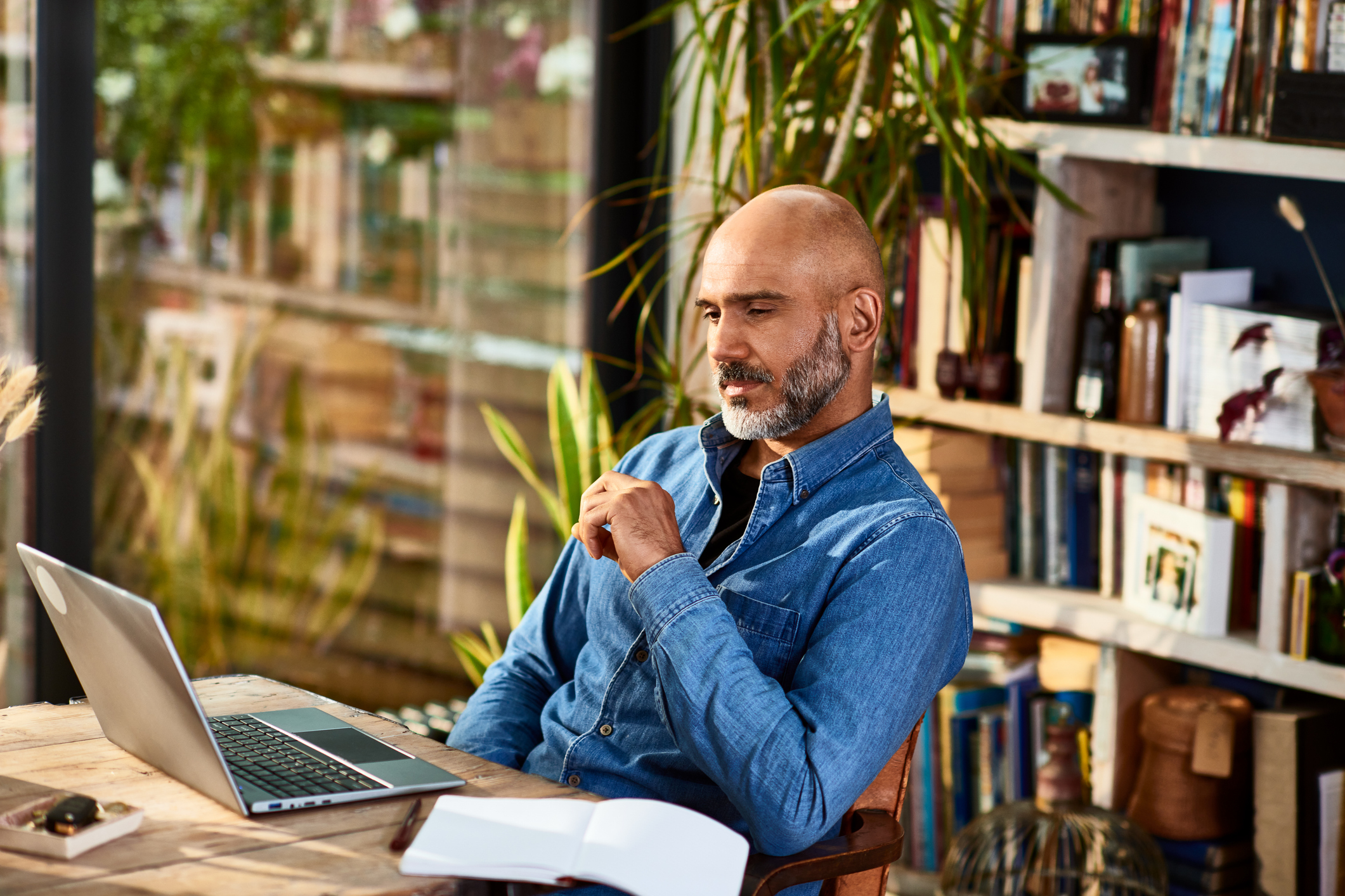 Handsome entrepreneur concentrating during virtual meeting on laptop, working from home, technology, connection.