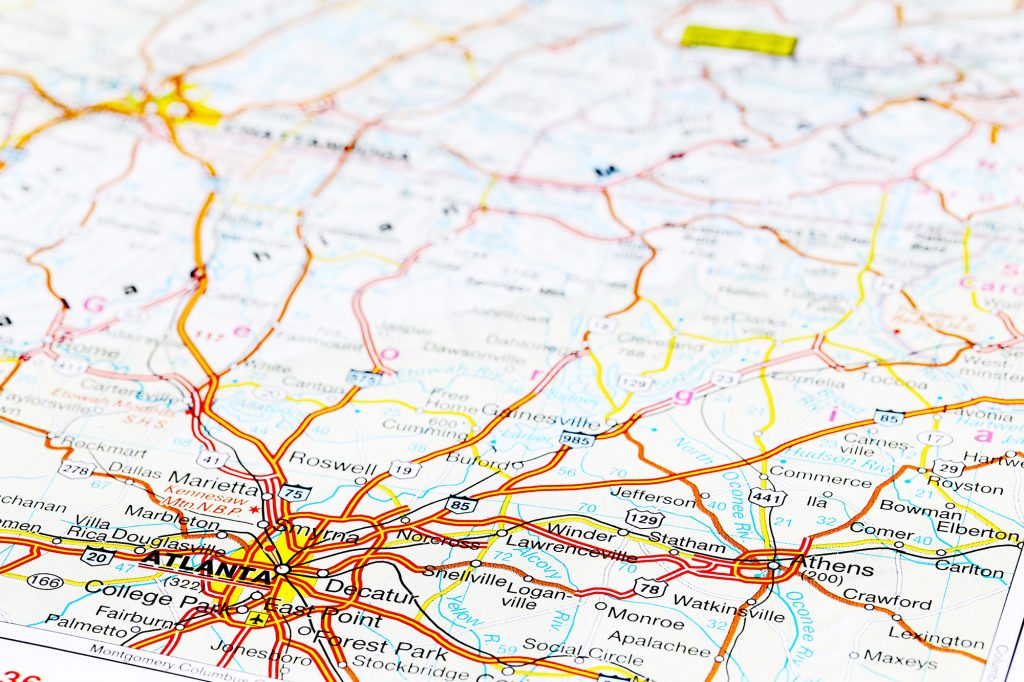 A close-up of a printed road map highlighting the Atlanta metro area, showing highways, cities, and regional routes in detail.