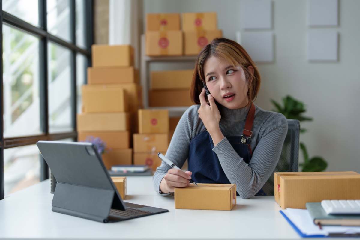 Franchise business owner managing customer orders while working at a small business office