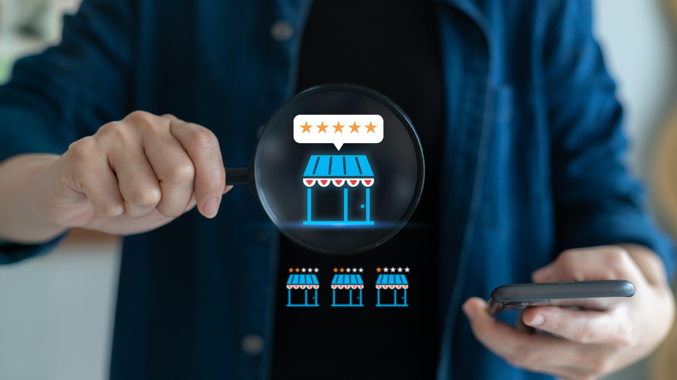 Persona sosteniendo una lupa frente a un ícono digital de una tienda con calificación de cinco estrellas, mientras utiliza un teléfono móvil, simbolizando la evaluación y análisis de franquicias rentables.