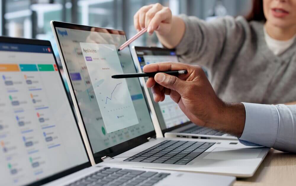 Equipo revisando métricas y gráficos para comparar las mejores franquicias de seguros para invertir.
