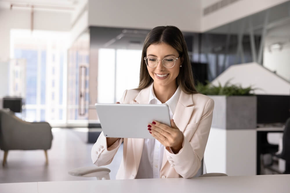 Emprendedora revisando información de negocios en una tableta, evaluando opciones entre las mejores franquicias en Texas para invertir.
