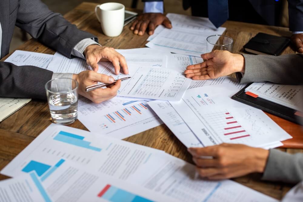 Empresarios analizando presupuestos y proyecciones financieras para determinar cuánto cuesta una franquicia de seguros.