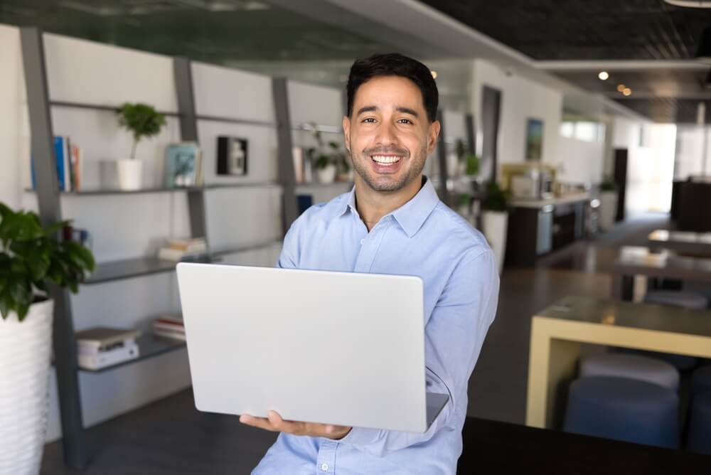 Emprendedor trabajando con una computadora portátil mientras explora opciones de franquicias internacionales para invertir en 2026.