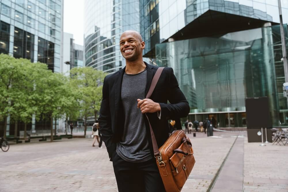 Emprendedor caminando por un distrito financiero mientras explora oportunidades de negocios rentables en New York y el crecimiento empresarial en la ciudad.