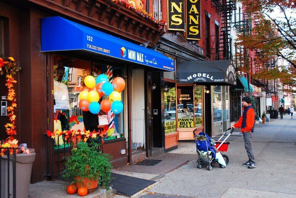Fachada de pequeños comercios en un barrio de Nueva York, ejemplo del tipo de negocios locales disponibles para compra por emprendedores e inversionistas.