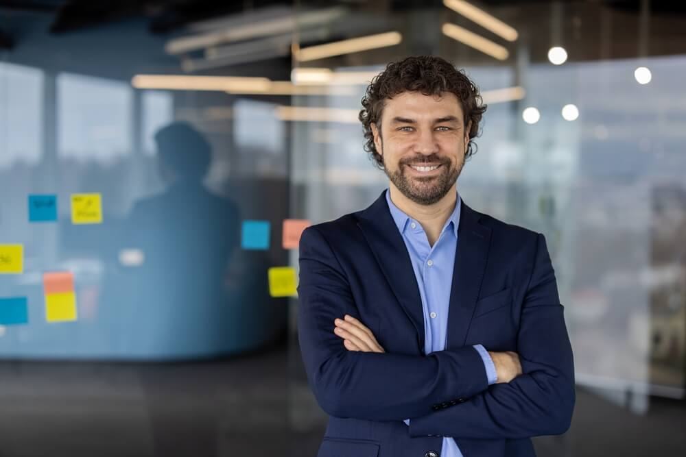 Empresario sonriente en oficina moderna representa oportunidades de franquicias en USA para extranjeros con la visa E2