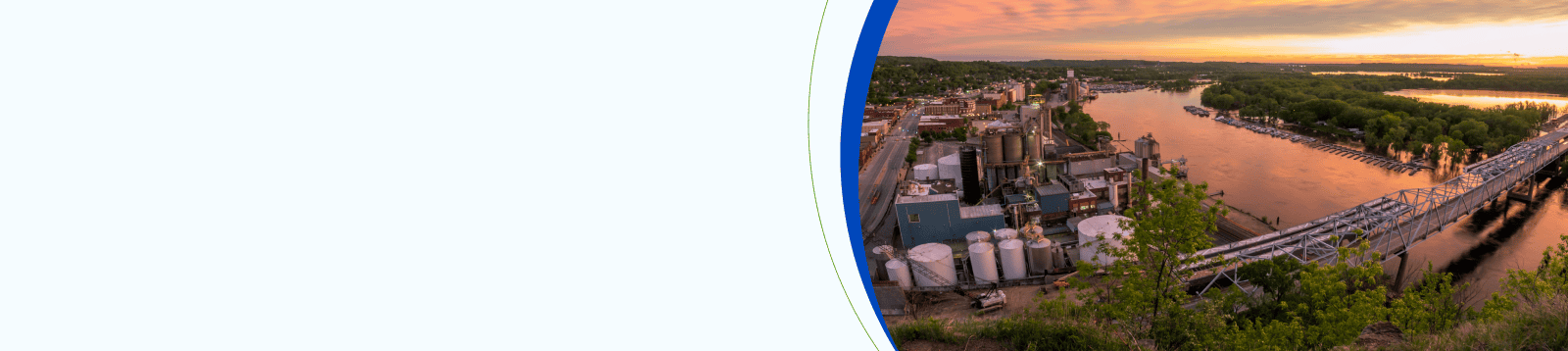 Aerial view of a busy street in downtown St. Louis, Missouri, with commercial buildings and city skyline under a partly cloudy sky.