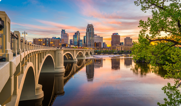 Minneapolis, Minnesota, USA downtown skyline on the Mississippi River with the Third Avenue Bridge at twilight.